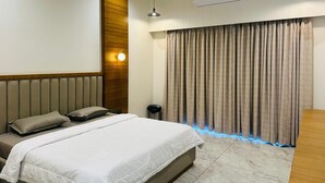 A bedroom with a bed, a wall-mounted air conditioner, a ceiling light, and a curtain with a blue light strip. - SRK Farm and Resort (Anjar)