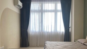 Een slaapkamer met een bed, een tafeltje en een bankje.