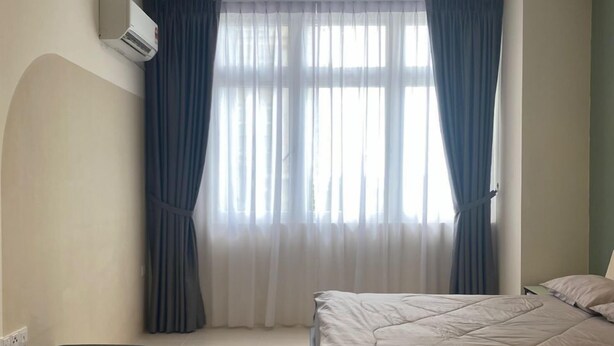 A bedroom with a bed, a small table, and a bench. - Riverine Diamond 5A, 4Pax Studio (Kuching)