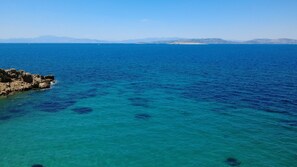 Vista costera con aguas azules cristalinas y costa rocosa.