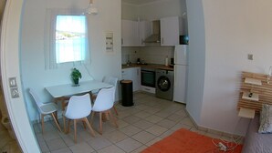 Une cuisine compacte avec un coin repas, comprenant une table, des chaises et un lave-linge.