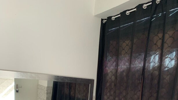A hotel room with a bed, a large mirror, and a window with curtains. - Studio with independent entrance in Madrid (Madrid)