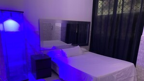 A bedroom with a bed, nightstand, and a wall-mounted shelf. - Studio with independent entrance in Madrid (Madrid)