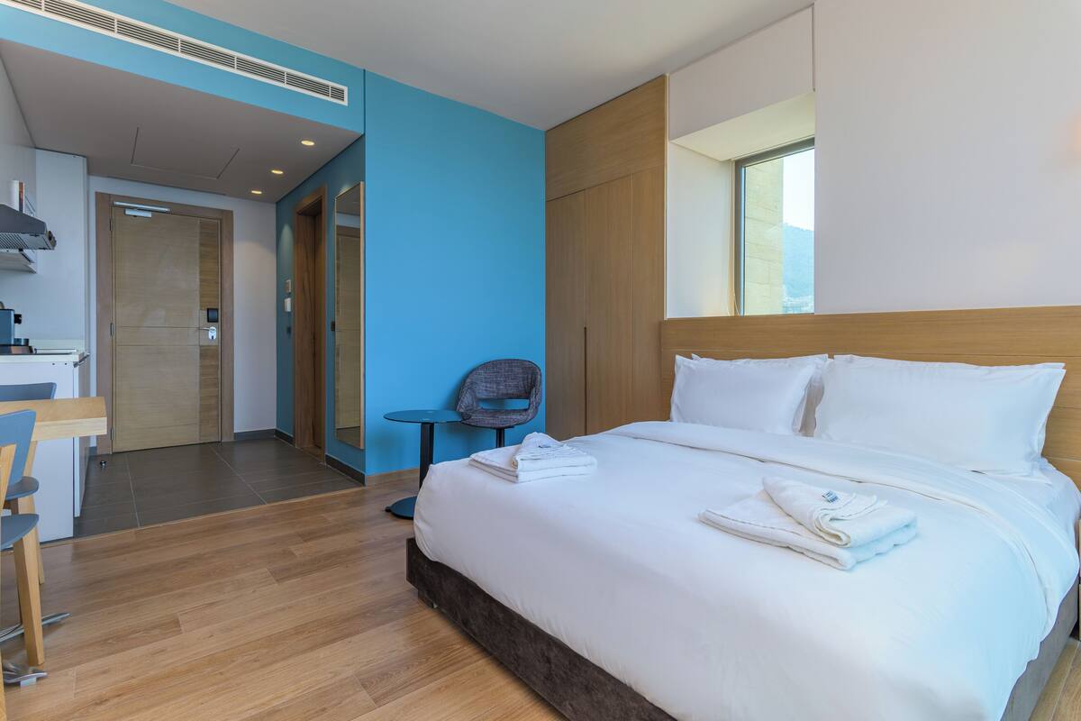 A hotel room with a bed, a desk, and a chair.