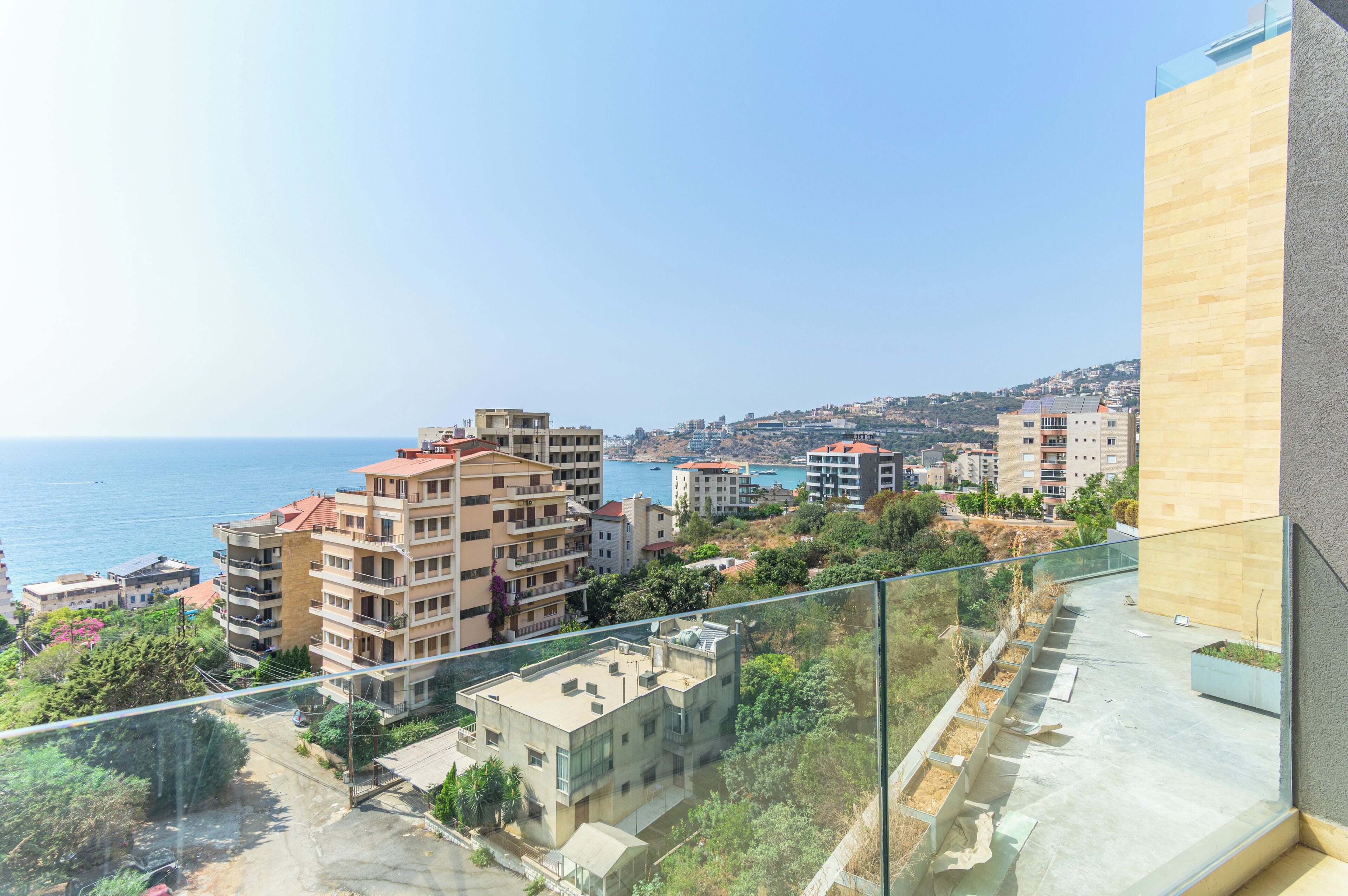 Un immeuble de grande hauteur offrant une vue sur la mer et sur d’autres bâtiments.