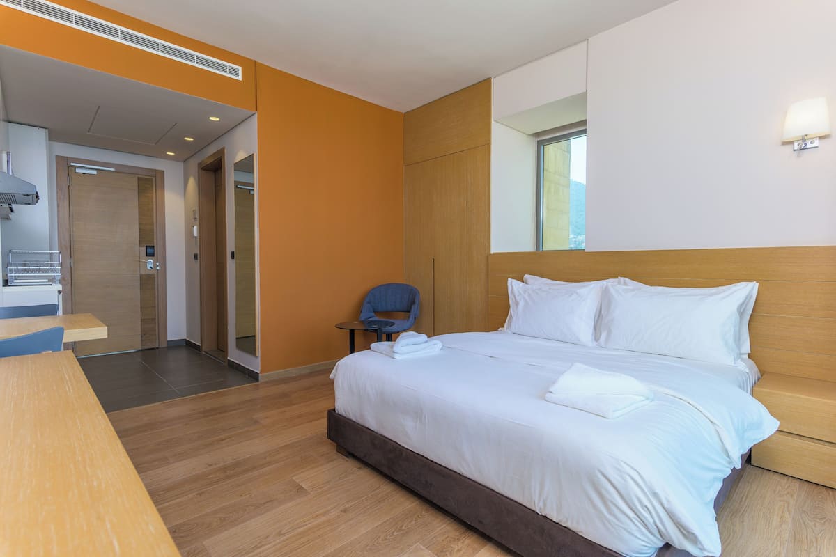 A hotel room with a bed, a desk, and a chair.