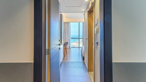 A hotel corridor with a view of the sea through large windows, a wooden floor, and a modern interior design. - Jounieh Living - Residences by Local Host (Jounieh)