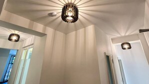 A hallway with a modern ceiling design and two wall-mounted light fixtures. - Bright loft in the heart of Paris (Liège)