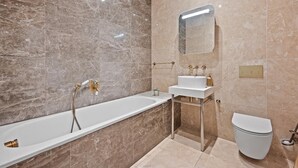 A modern bathroom with a bathtub, a vanity with a sink, and a toilet. - Brampton Grove Cozy Apartment - London (London)