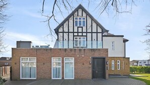 A two-story house with a brick facade, large windows, and a modern design. - Brampton Grove Cozy Apartment - London (London)