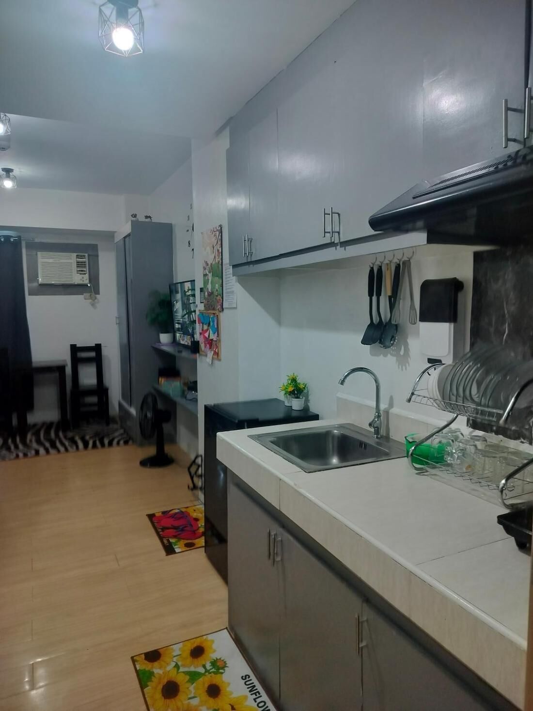 Une cuisine moderne dotée d’un évier encastré, d’un coin repas avec une table et des chaises, et d’un ventilateur de plafond.