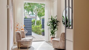 A modern interior with two armchairs, a small table, and a potted plant.