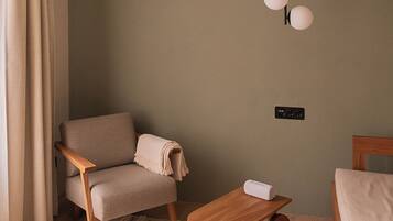 A cozy living room with a beige sofa, a wooden coffee table, and a hanging light fixture.