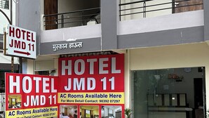 A hotel with a signboard advertising AC rooms and contact details. - Hotel JMD 11 (Indore)