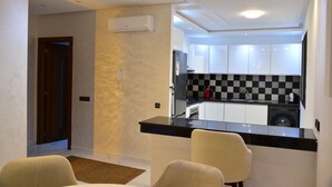 A modern kitchen with a black countertop, white cabinets, and a checkered backsplash.