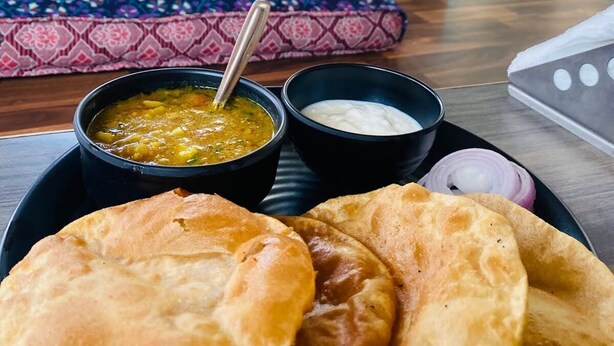 A dining setup with flatbreads, a bowl of soup, and a bowl of yogurt. - The Pink Chapter Hostel, Jaipur (Jaipur)