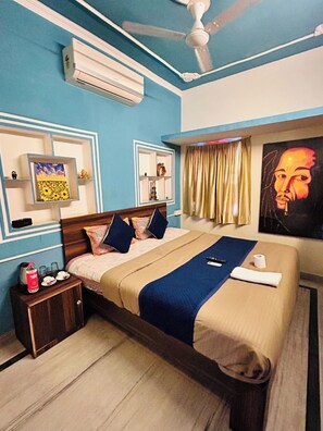 A hotel room with a bed, bedside table, and a ceiling fan. - The Pink Chapter Hostel, Jaipur (Jaipur)