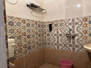 A bathroom with floral patterned tiles, a toilet, a sink, and a shower area. - The Pink Chapter Hostel, Jaipur (Jaipur)