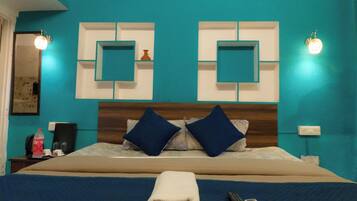 Une chambre d’hôtel avec un grand lit, deux lampes fixées au mur et un climatiseur fixé au mur.