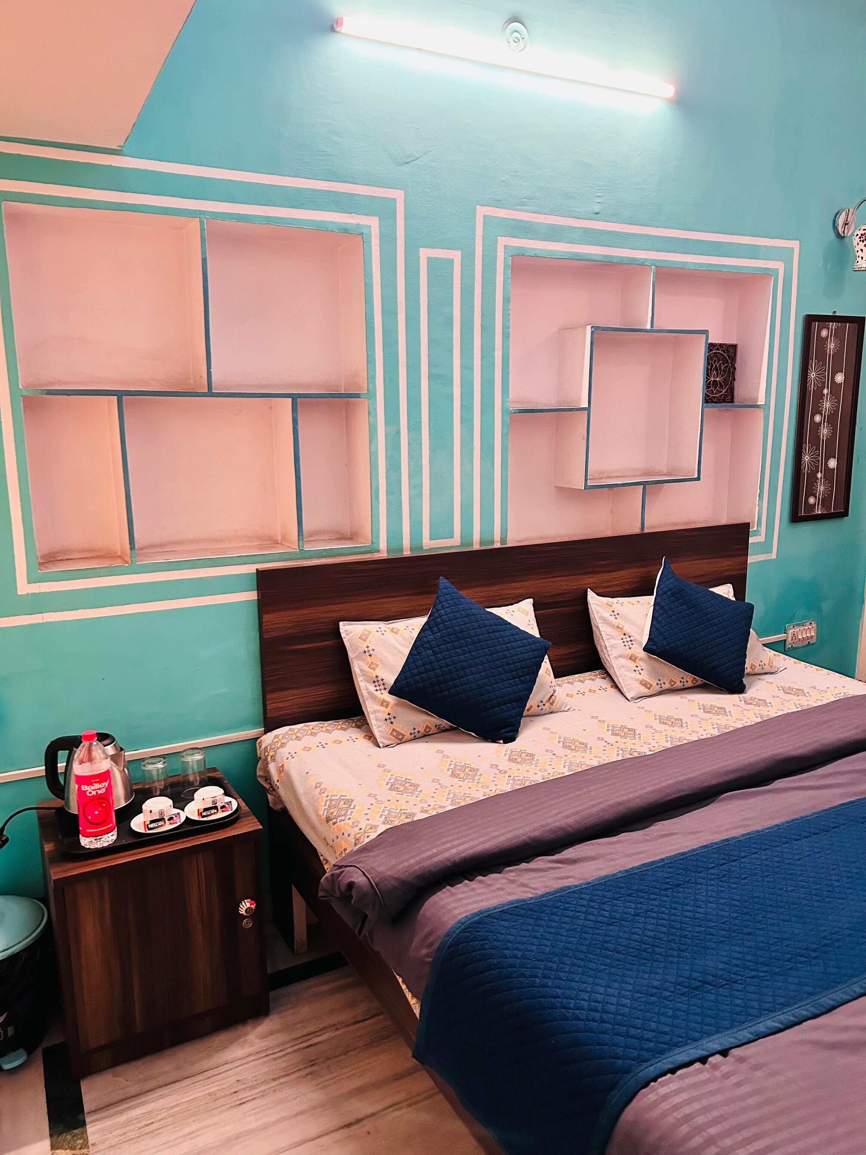 A bedroom with a bed, bedside tables, and a wall with geometric patterns.