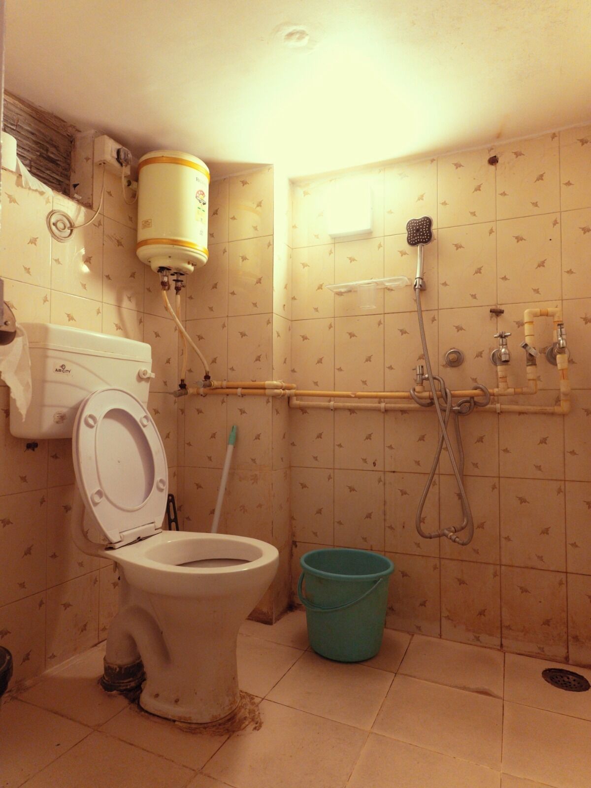 Un baño pequeño y sencillo con inodoro, ducha y un cubo.