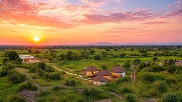 Un paisaje rural con un grupo de casas bajo un cielo despejado al atardecer.