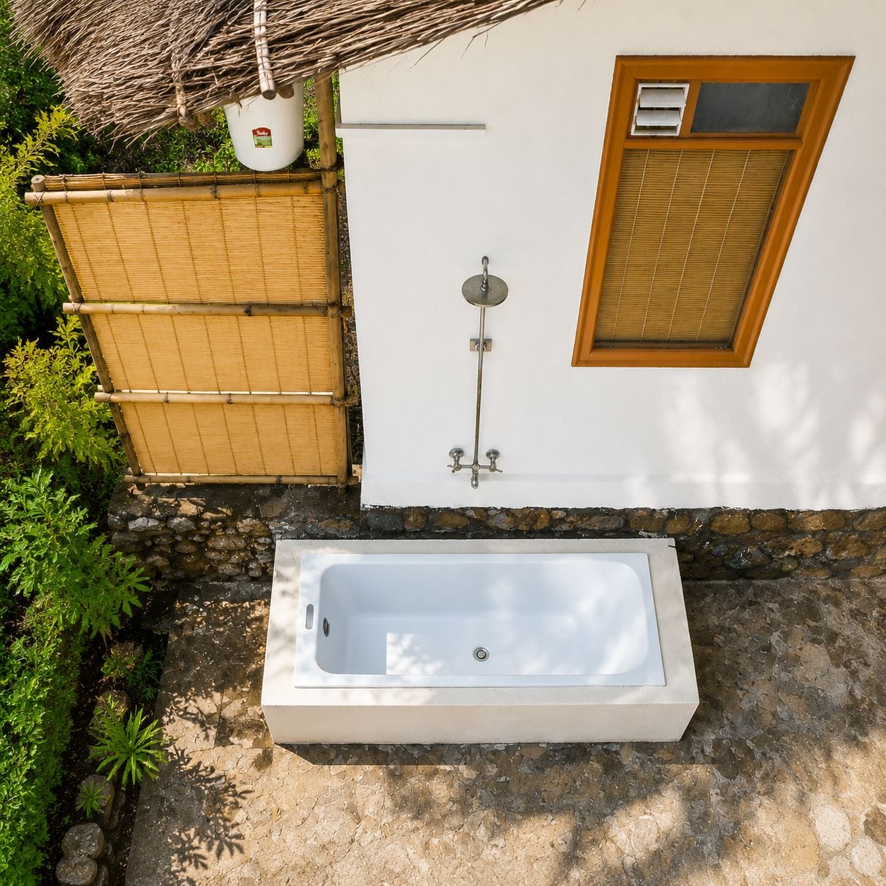 A bathroom with a bathtub, a shower, and a window with blinds.