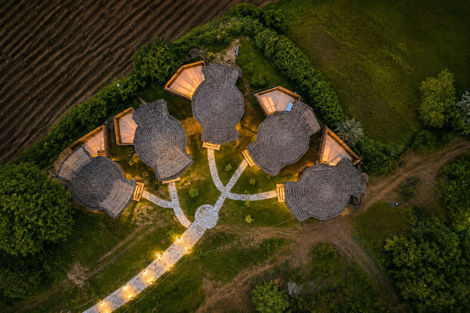 An aerial view of a cluster of hexagonal-roofed buildings with interconnected pathways.