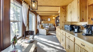 Un intérieur de chalet chaleureux et accueillant, comprenant un coin repas, un canapé et une petite cuisine.