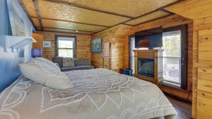Une chambre dans un chalet en bois, avec un lit, une cheminée et une fenêtre.