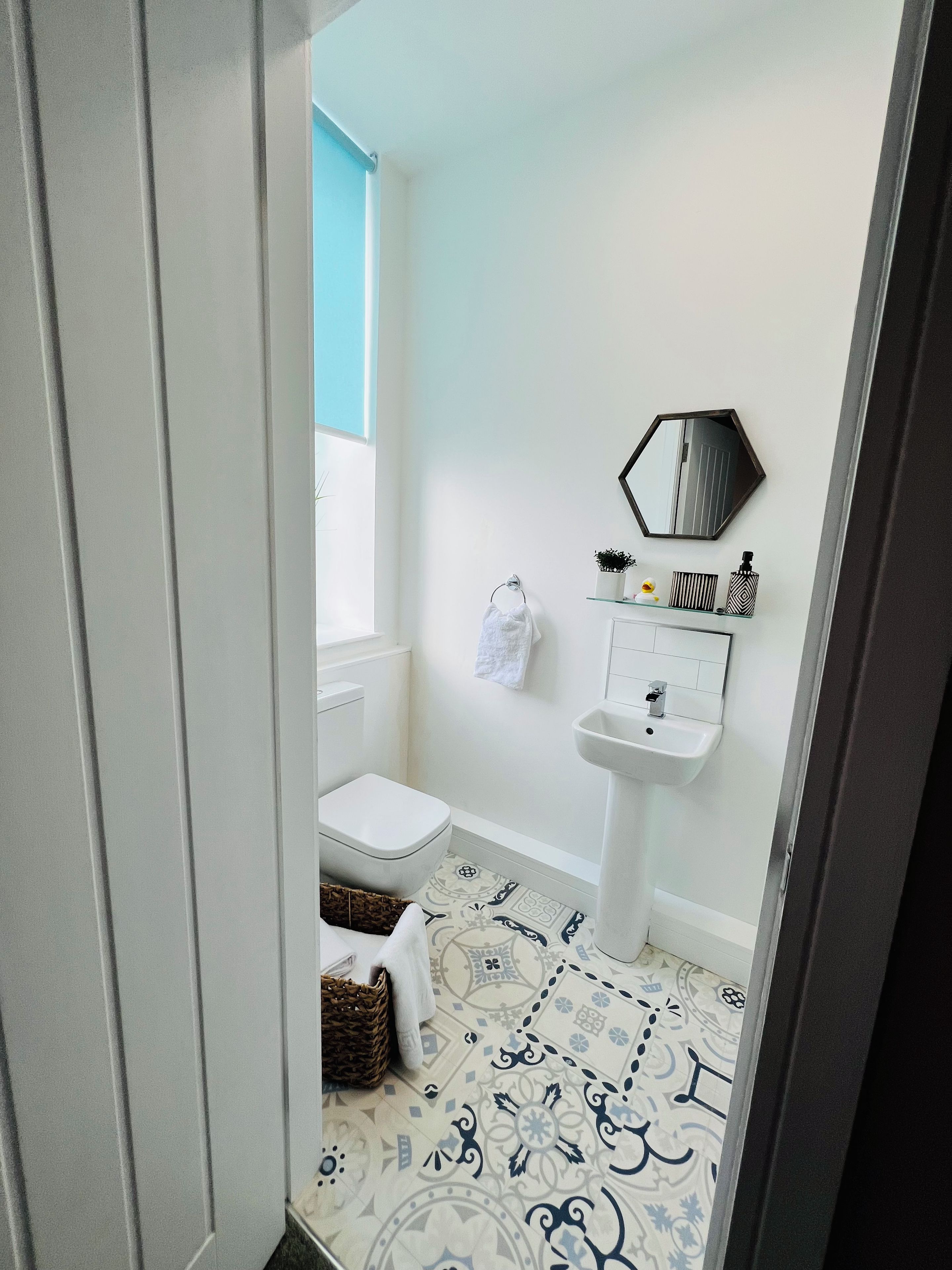 Un baño con inodoro, bidé, lavabo y un espejo en la pared.