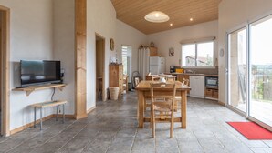 A spacious kitchen with a dining area, wooden ceiling, and large windows. - Holiday Home 'Eco Gîte' with Mountain View, Wi-Fi and Air Conditioning (Payzac)