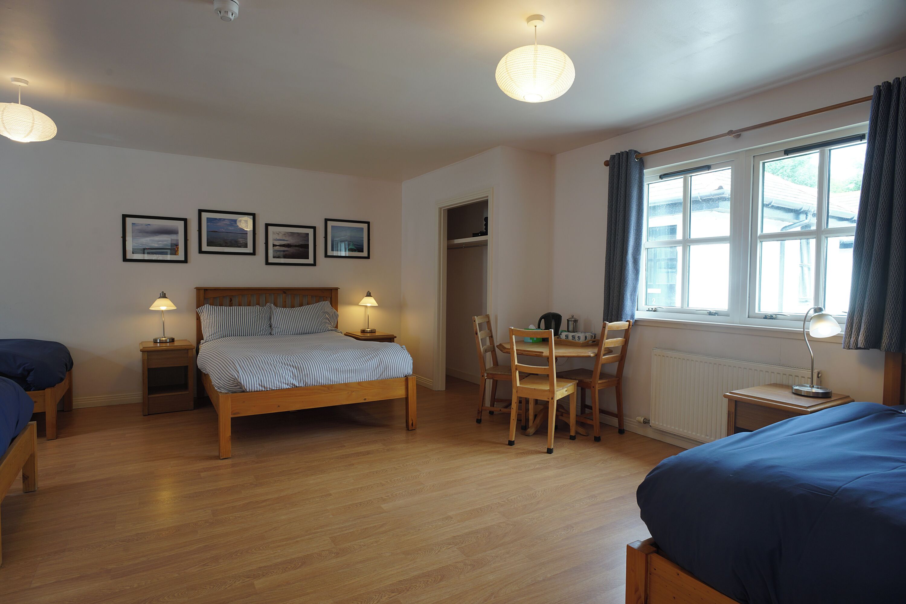 A bedroom with a bed, bedside tables, a desk, and chairs.