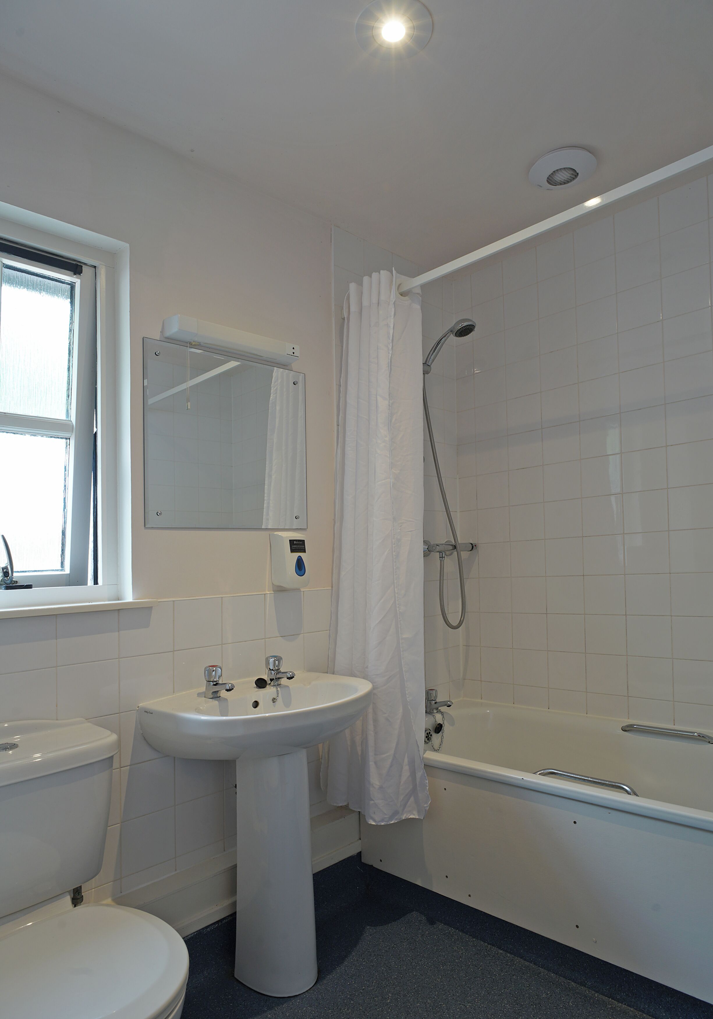 A bathroom with a toilet, sink, and bathtub.