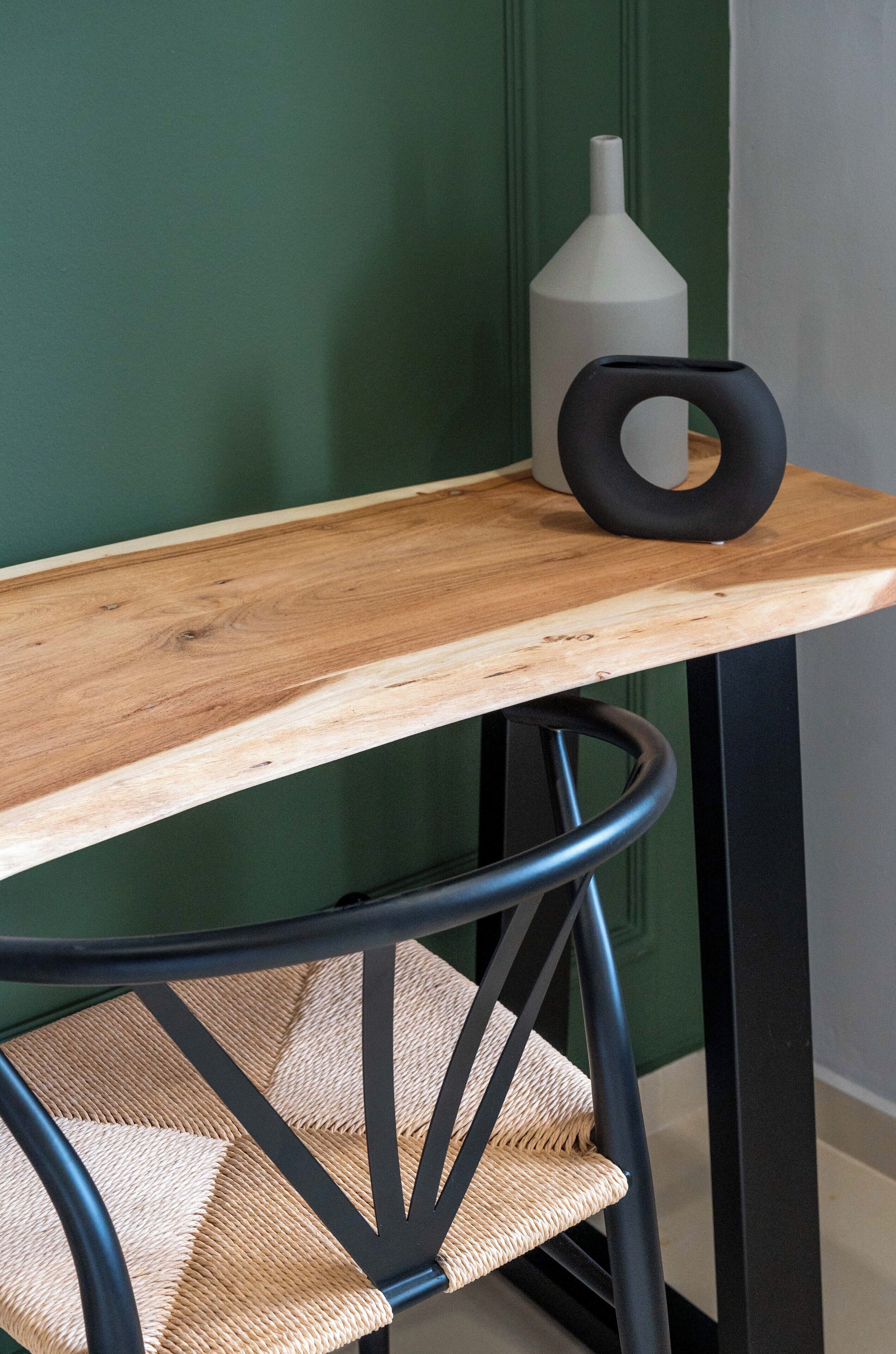 A wooden table with a black metal chair.