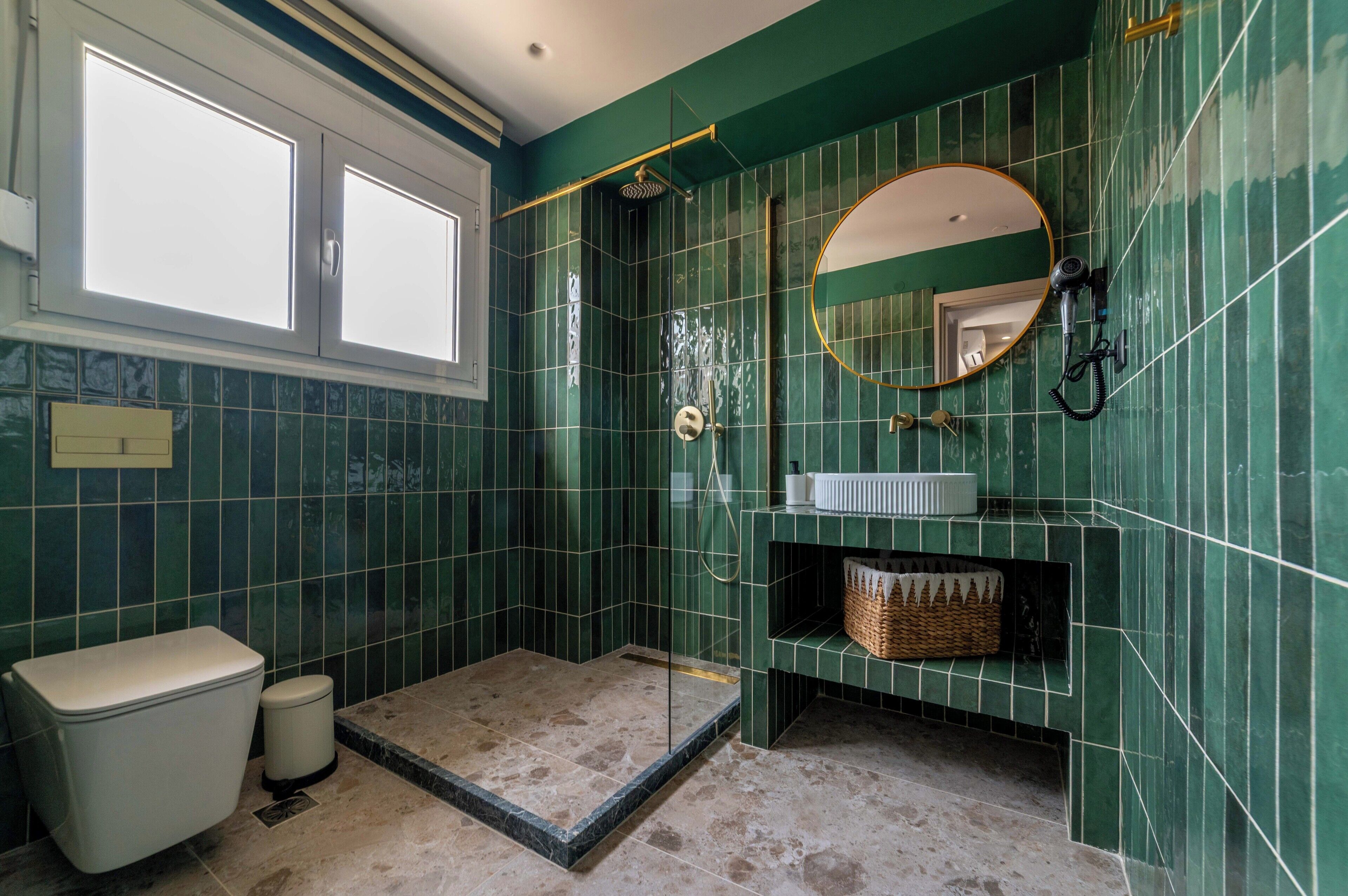 Une salle de bain équipée d’une douche, de toilettes et d’un meuble-lavabo avec un miroir.