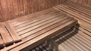 A wooden sauna with a bench and benches, a slatted floor, and a wooden wall. - MeLou Fewo NaturQuartier Wellness (Bad Lauterberg)