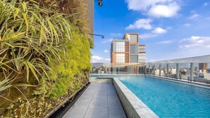 A rooftop pool with a city view, surrounded by lush greenery and modern architecture. - Your Perfect and Exclusive Stay in the Heart of Itaim Bibi - DSG (São Paulo)