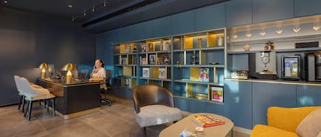 Un espace d’accueil moderne comprenant un comptoir, des sièges et un bar à café.