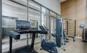 A gym with treadmills, an elliptical, and weight machines.