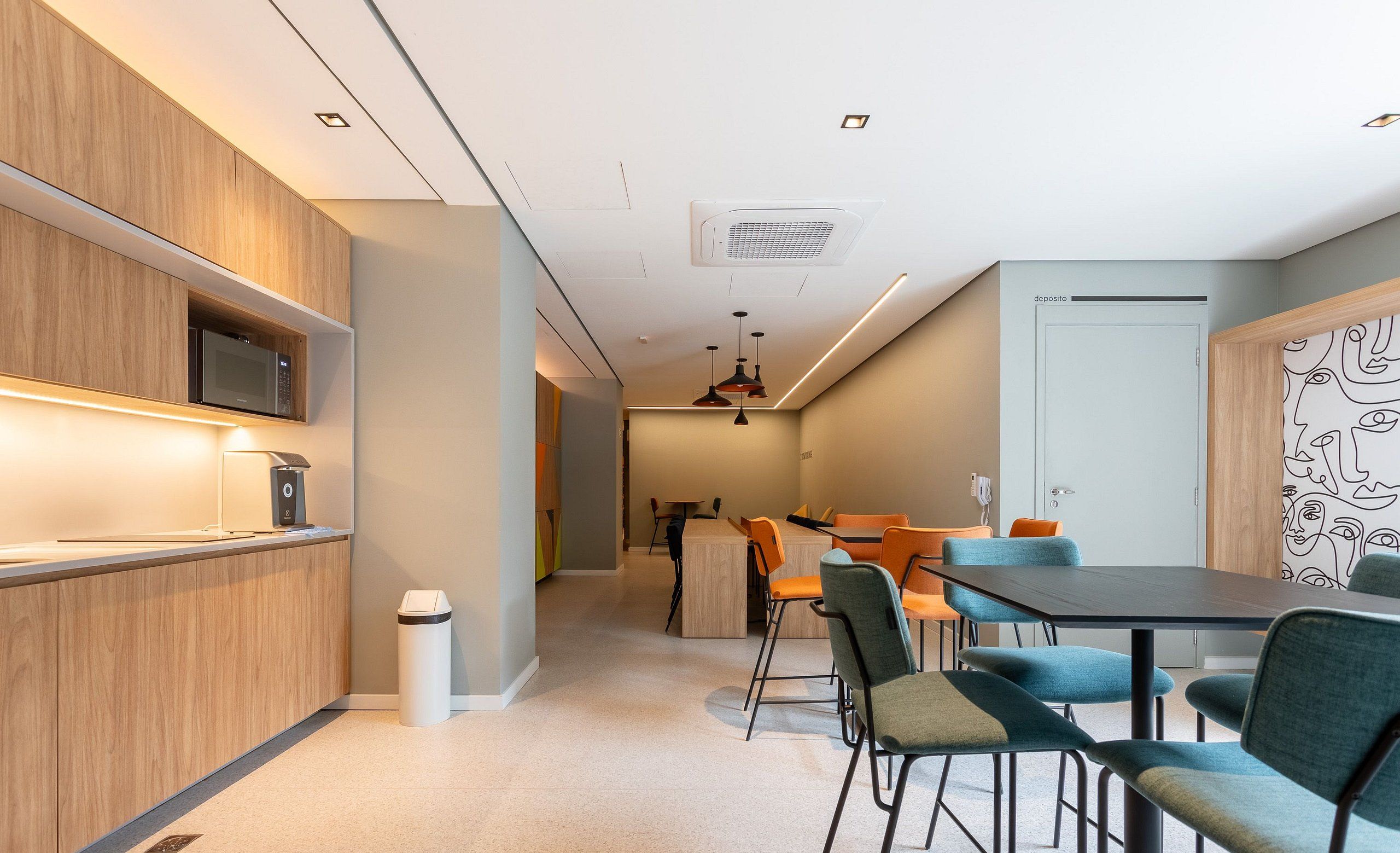 A modern kitchen with built-in appliances, a dining area with a table and chairs, and a hallway leading to another room.