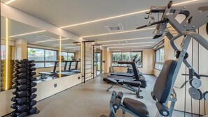 Ένα γυμναστήριο με όργανα γυμναστικής, διαδρόμους και μια σειρά από αλτήρες.