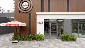 A modern building with a circular logo, a security umbrella, and a number 1543 on the facade. - Estúdio em SP perto do metrô | GBA908 (São Paulo)