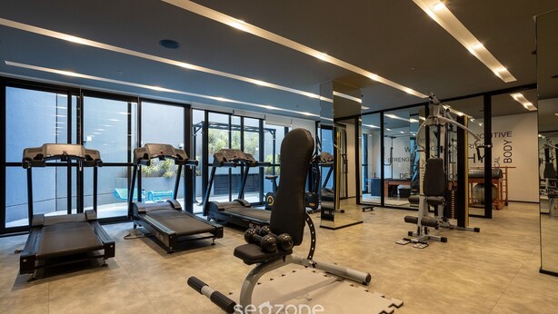Un gimnasio moderno con cintas de correr, máquinas de pesas y pesas libres.