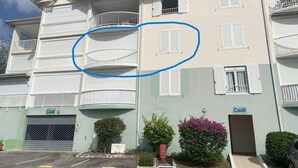 A multi-story building with balconies, a garage door, and a sign reading "Caiali". - Superb Caiali Blue apartment (Les Trois-Îlets)