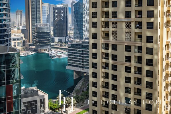 A high-rise building with a view of a marina and other modern buildings. - LUX The Luxury Sunny JBR Beach Views 2 (Dubai)