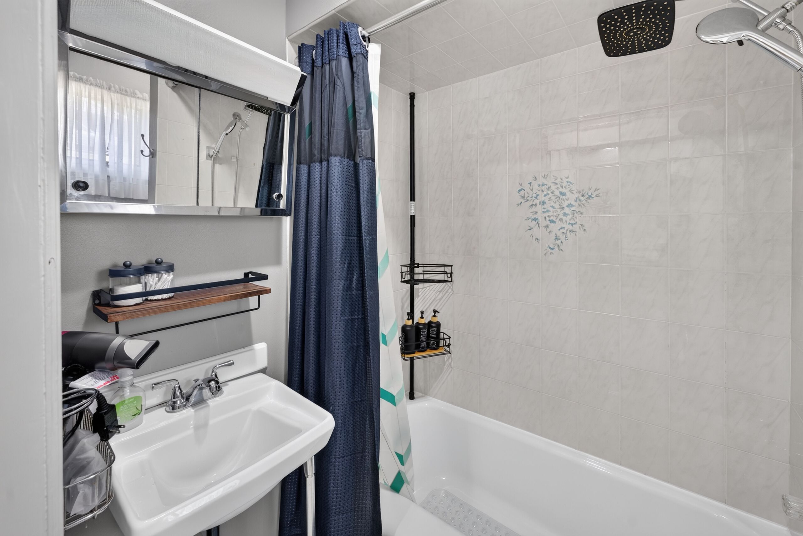 Une salle de bain avec une douche, un lavabo et un miroir.