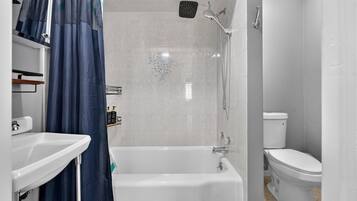 A bathroom with a bathtub, toilet, and shower.