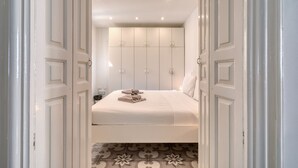 A hotel room with a neatly made bed, a wardrobe with multiple doors, and a patterned floor. - Impressive 3 bedrooms, sun terrace, jacuzzi AMRA1-1 (Sliema)