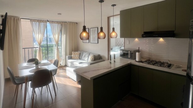 Um apartamento moderno com área de refeições, sala de estar e cozinha.